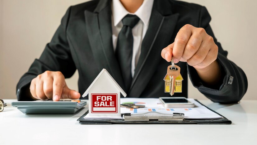 modèle de maison mis sur les papiers de prêt Immobilier avec un homme d'affaires détenant des clés